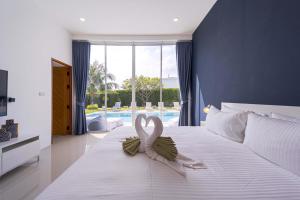 a room with a bed with a pink ribbon on it at Harmony Villa 5 Bedroom Modern Pool Villa - KH-A7 in Khao Tao +78 photos