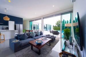 a living room with a blue couch and a table at Harmony Villa 5 Bedroom Modern Pool Villa - KH-A7 in Khao Tao