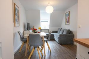 Una sala de estar con una mesa y sillas y un sofá. en Kaisercity Apartment 3, en Núremberg
