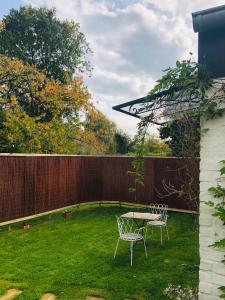 a patio with two chairs and a table in a yard at Small peaceful haven in Céroux-Mousty in Mellet