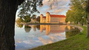 a large building with a reflection in the water at Olivia in Rheinsberg