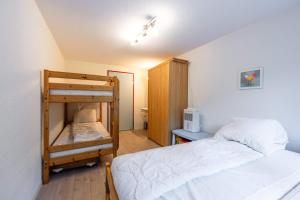 a bedroom with two beds and a bunk bed at Large Apartment In The Vacation Center Whirlpool in Diemtigen