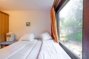 two beds in a room with a window at Large Apartment In The Vacation Center Whirlpool in Diemtigen