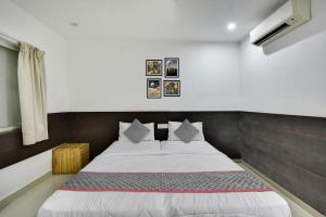 a bedroom with a bed with white sheets and pillows at Collection O Elite Residency in Chennai