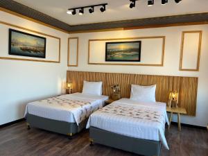duas camas num quarto de hotel com duas lâmpadas em Bien Ngot Resort Phu Quoc em Duong Dong