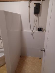 a bathroom with a shower stall with a toilet at Pradu House 