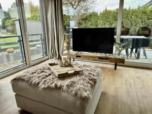 een woonkamer met een bank en een televisie bij PIERSIDE - Pier 2 in Haffkrug