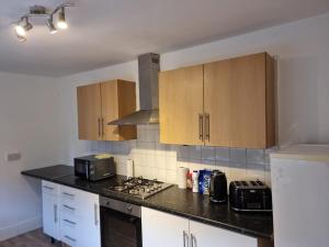 a kitchen with white cabinets and a black counter top at Sigma Elegance Free Parking in Tynemouth