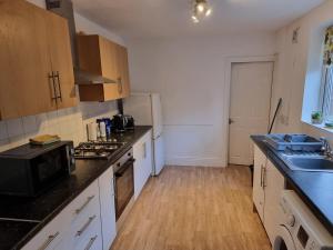 a kitchen with white cabinets and a black counter top at Sigma Elegance Free Parking in Tynemouth