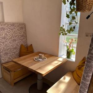 - une table en bois dans une chambre avec fenêtre dans l'établissement Eichenhäuschen - Tinyhouse im Weinviertel, à Kleinstelzendorf
