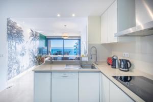 une cuisine avec des armoires blanches et une vue sur l'océan dans l'établissement Seaview Horizon, à Punta Prima