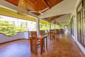 a dining room with wooden tables and chairs at Serendipity Beach Hotel in Unawatuna