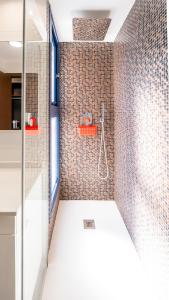 La salle de bains est pourvue d'une douche et d'un mur en carrelage. dans l'établissement Seaview Horizon, à Punta Prima