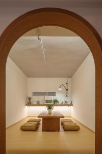 an archway in a room with a table and benches at 船长五号青年酒店-上海中山公园江苏路地铁站店 in Shanghai