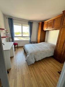 a bedroom with a bed and a desk and a window at Rêver en bord de mer in Saint-Michel-Chef-Chef