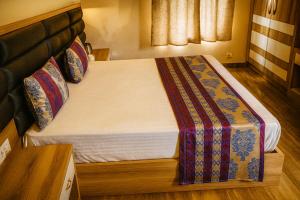 a bedroom with a large bed with a wooden headboard at Virat Resorts, Sariska Rajasthan in Bairāt