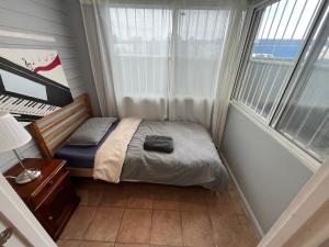 a small bedroom with a bed and a piano at Airport Guesthouse in Sydney