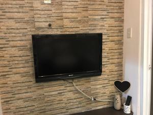a flat screen tv mounted on a brick wall at Chloe's Place Tagaytay Taal View Staycation Condo in Tagaytay