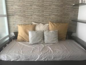 a bed with several pillows on top of it at Chloe's Place Tagaytay Taal View Staycation Condo in Tagaytay +16 photos