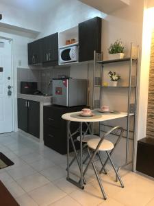 a kitchen with a table and chairs and a microwave at Chloe's Place Tagaytay Taal View Staycation Condo in Tagaytay