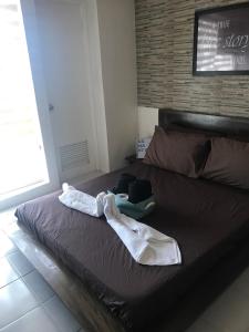 a bed with two towels on top of it at Chloe's Place Tagaytay Taal View Staycation Condo in Tagaytay