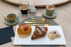 a table with a plate of pastries and cups of coffee at Verus Room in Caltagirone