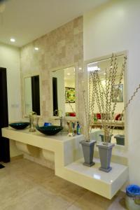 a bathroom with two sinks and two mirrors at فيلا راحتي بدخول ذاتي in Unayzah