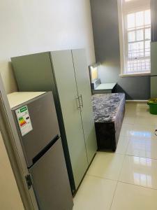 ダーバンにあるVictoria Waterfront Lodgeの小さな客室で、冷蔵庫、テーブルが備わります。