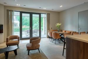 a dining room with tables and chairs and a large window at Droomsuites Texel 4 personen by Droomvilla in Den Burg