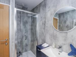a bathroom with a shower and a sink and a mirror at Morannedd in Pwllheli +16 photos