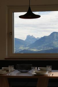 a table with a view of a mountain through a window at Alpenglow Apartments in Collalbo +30 photos