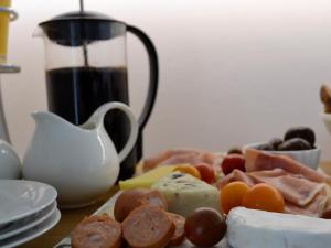 a plate of food with meat and cheese on a table at Oceans Drift Guest House & Self Catering in Simonʼs Town