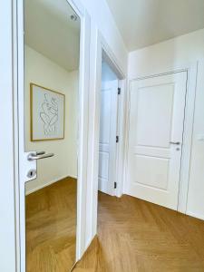 an empty room with a white door and wooden floors at San Lorenzo Apartment in Giaveno