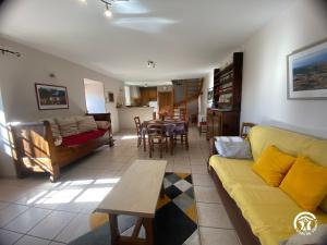 a living room with a yellow couch and a table at Gîte de caractère à Verlac in Verlac