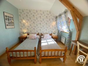 a bedroom with two beds and a window at Gîte de caractère à Verlac in Verlac