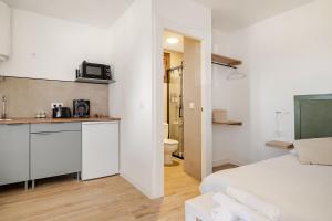 a white room with a bed and a bathroom at Tiny house with sunset over the ocean in Oia