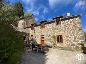 a stone house with a table in front of it at Gîte de caractère à Verlac in Verlac