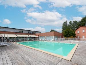 a large swimming pool with a wooden deck at Vacancéole - Domaine du Green in Rivières +25 photos