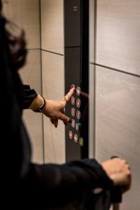 a person is pressing buttons on a elevator at Grand Hotel Dore in Paris