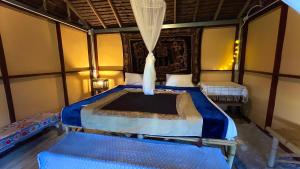 a bedroom with a bed and two benches in it at Hula Hula Bungalow in Ban Wiang Nua