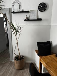 NiederdorlaにあるEASY by Interior Apartmentsの鉢植えと時計のあるリビングルーム