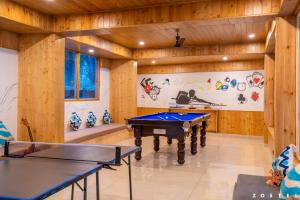 Zostel Kasol, Main Market في كاسول: طاولة بلياردو في غرفة مع جدران خشبية