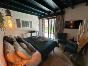 a bedroom with a large bed and a large window at "Belle An Pierre" chambres d hôtes & spa à 15 minutes du Futuroscope, 3 minutes du lac de St Cyr et du Golf du haut Poitou in Saint-Cyr