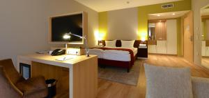 アルツァイにあるWeinhotel Kaisergartenのベッド、デスク、椅子が備わるホテルルームです。