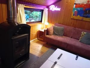 a living room with a couch and a wood stove at fraai chalet Barvaux in Durbuy