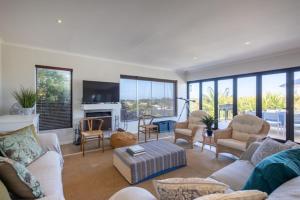 a living room with couches and chairs and a fireplace at 9 Pladda Drive in Plettenberg Bay