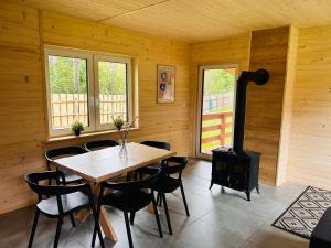 a dining room with a table and a wood stove at Bolek i Lolek domki do wynajęcia in Popielżyn Dolny