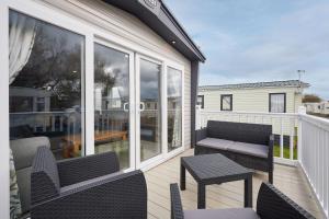 een balkon met stoelen, een bank en een tafel bij Host & Stay - Grange in Morecambe