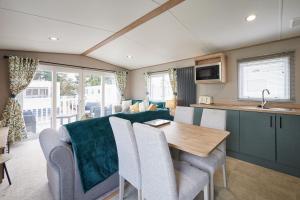 een caravankeuken en woonkamer met een tafel en stoelen bij Host & Stay - Grange in Morecambe +13 foto's