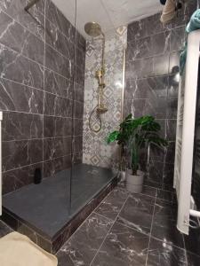 a bathroom with a shower with a black tiled wall at Bagnol Chill - 4 personne - 30 mn avignion in Bagnols-sur-Cèze
